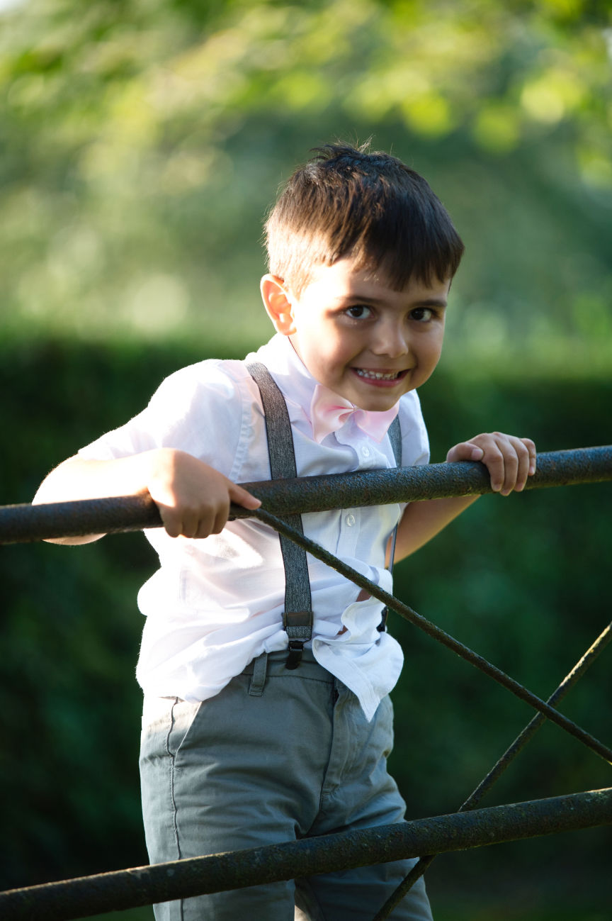 Young boy swings on the gate at Lyme breeze wedding venue, Macclesfield