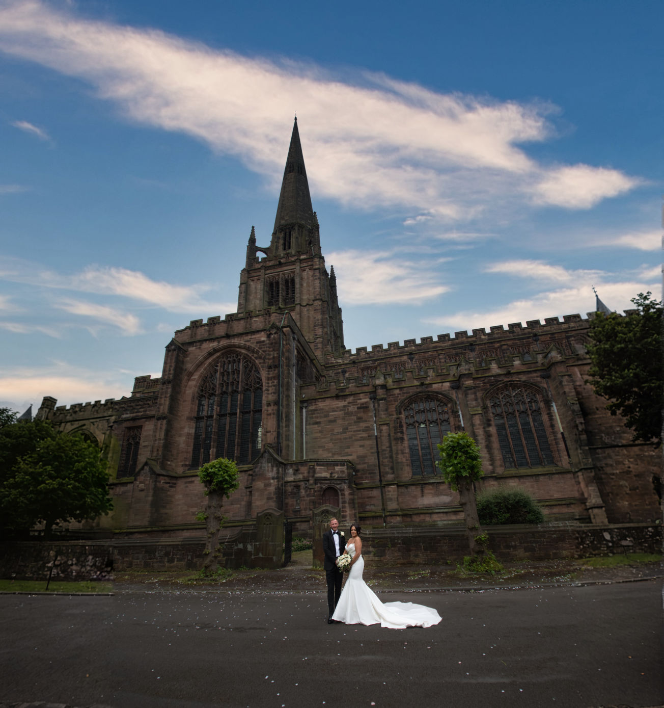 A bride and groom with Saint Georges Church London Road, Stockport in the background